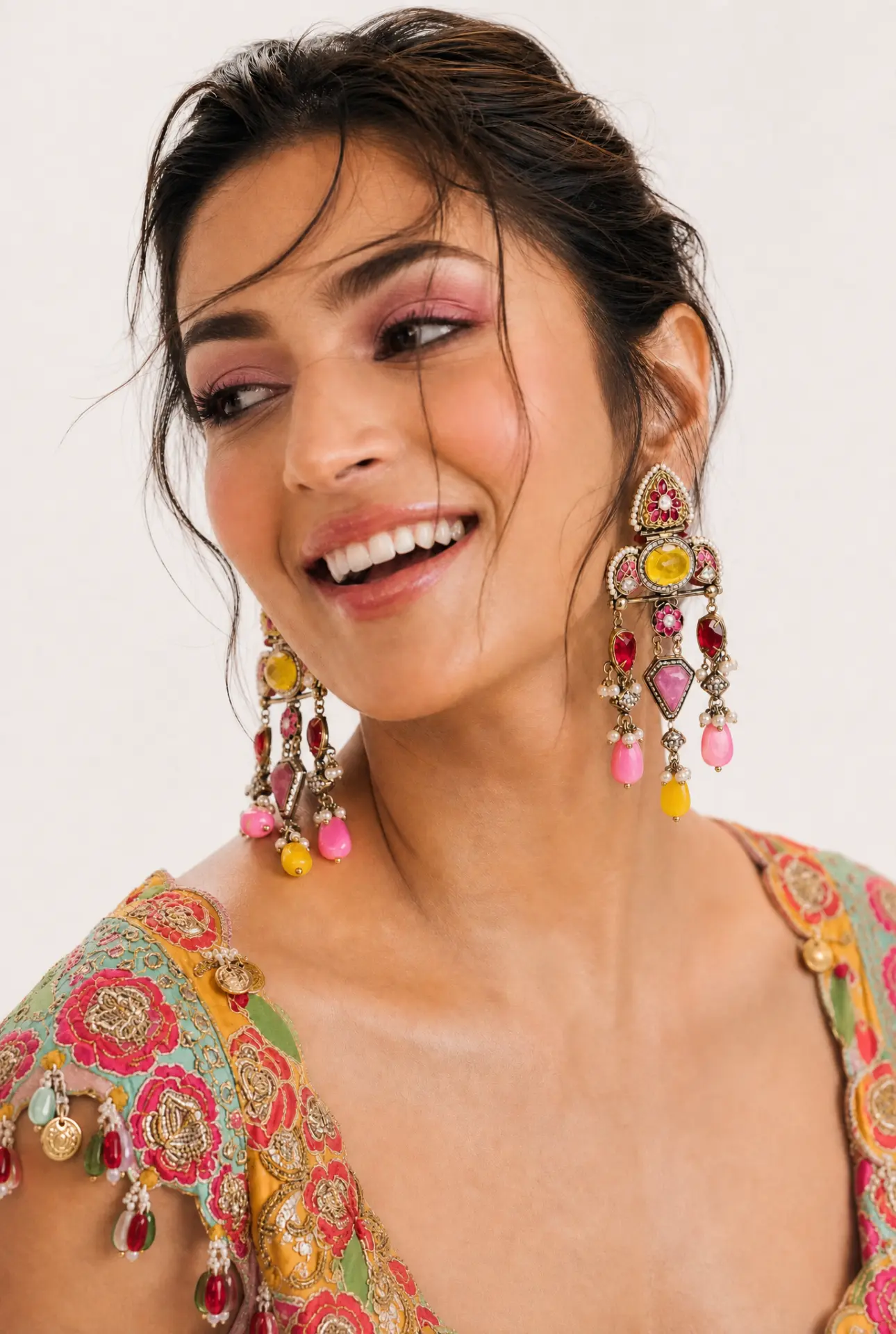 Smiling bride in multicoloured lehenga wearing colourful kundan chandelier earrings