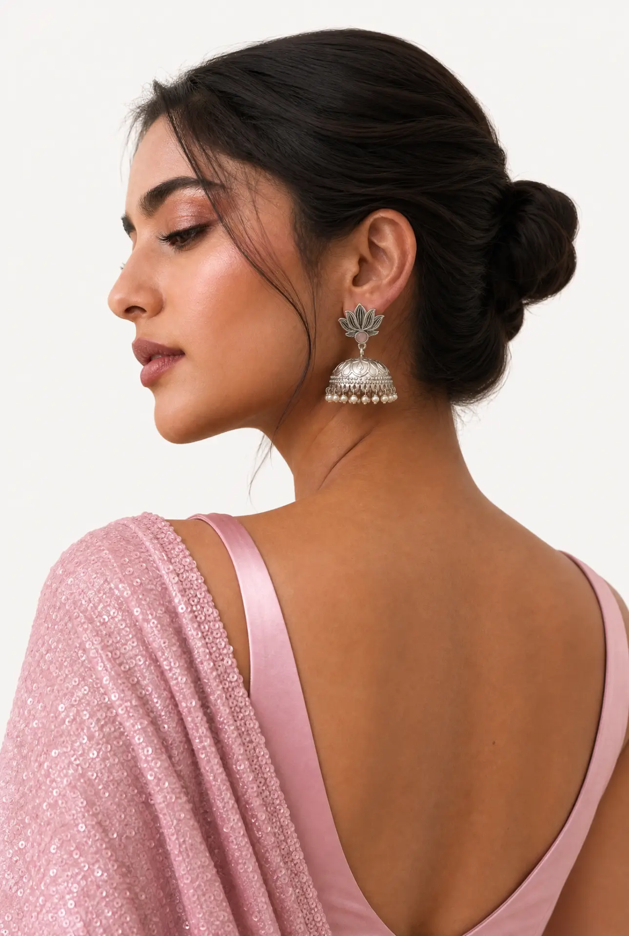 Model in a pink sequin saree wearing oxidised silver lotus jhumka earrings